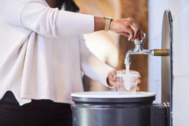 Personne qui se sert un verre d'eau