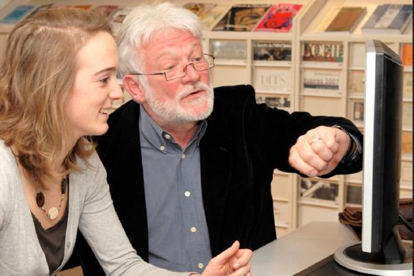 Discussion entre deux personnes devant un ordinateur