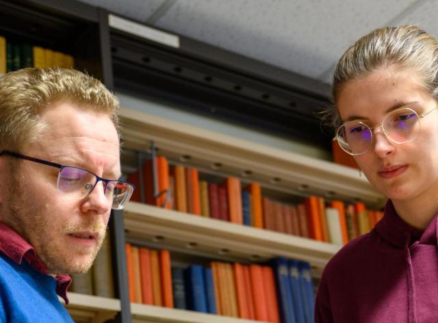 Etudiante et professeur dans une bibliothèque