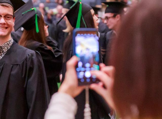 Parent qui prend en photo son enfant diplômé à l'UNamur