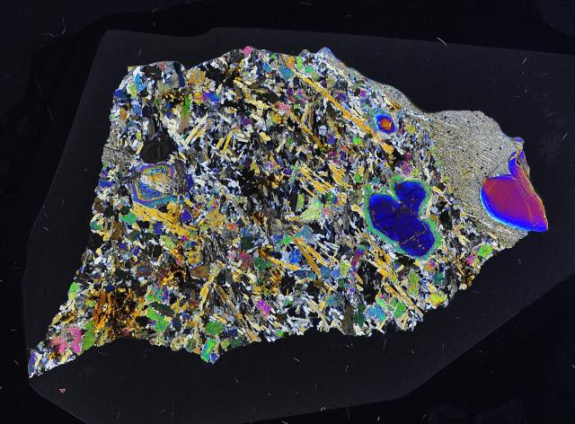 La météorite Erg Chech 002, la roche magmatique la plus ancienne du système solaire (4,5 milliards d’années), vue au microscope polarisant (4 cm de long)