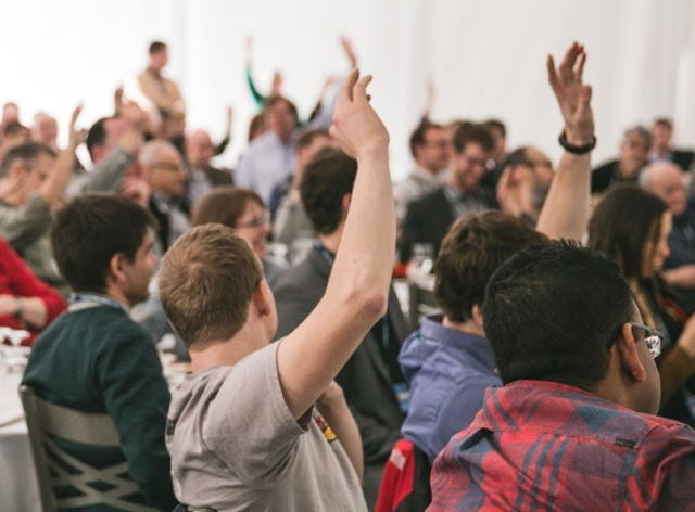 Une assemblée de personnes qui votent à main levée