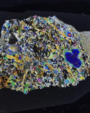 La météorite Erg Chech 002, la roche magmatique la plus ancienne du système solaire (4,5 milliards d’années), vue au microscope polarisant (4 cm de long)