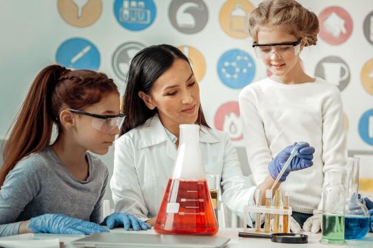 Photo représentant une femme et des jeunes filles avec du matériel scientifique