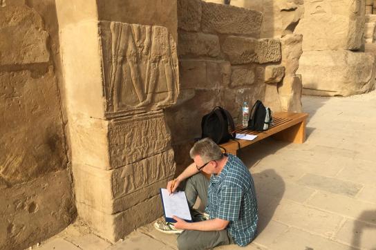 Photo de René Preys examinant des hiéroglyphes